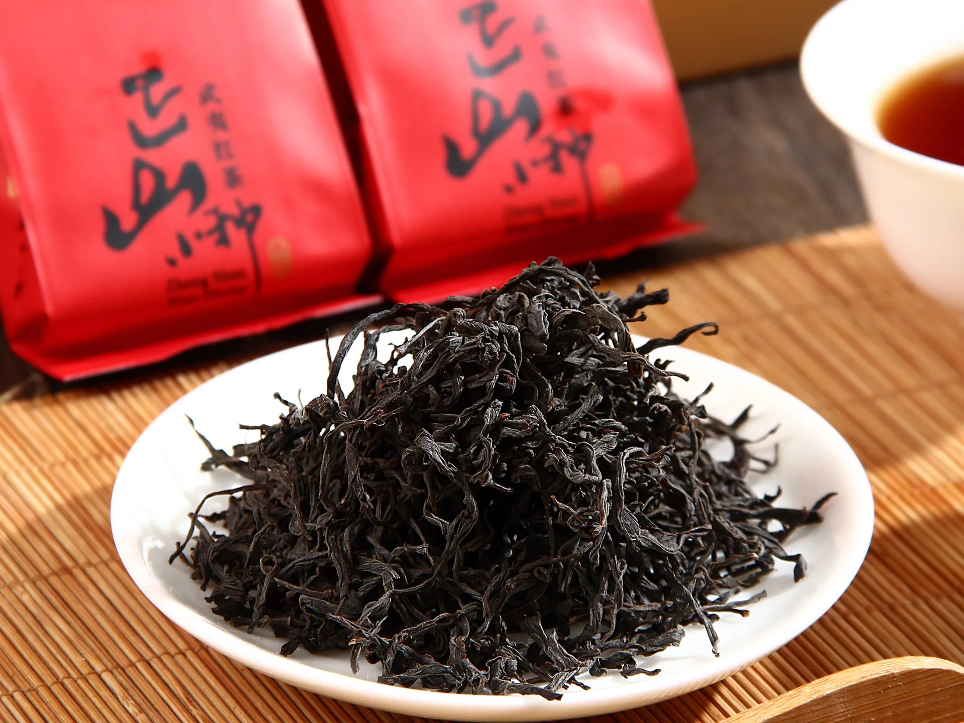 见山正山小种 · 干茶盘（盘中条索 + 红袋虚化）